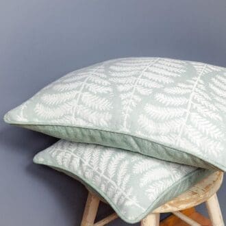 Cushions featuring a delicate fern motif sat atop a vintage stool.