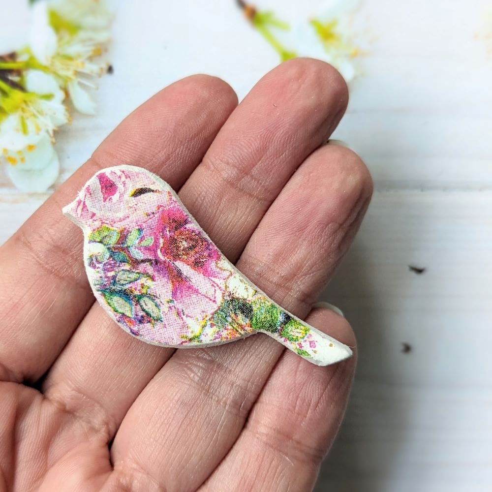 Small clay bird brooch decoupaged with a pink floral design