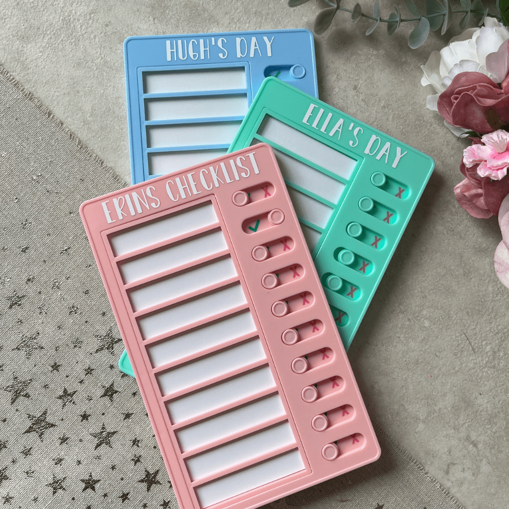 3 personalised children's checklists in pastel blue, pink and green.