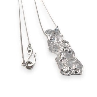 Sterling silver reticulated organic pendant and chain lying on a white background
