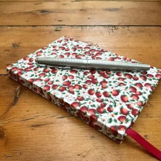 Small A6 hard cover plain paper handmade notebook covered in Strawberry print fabric