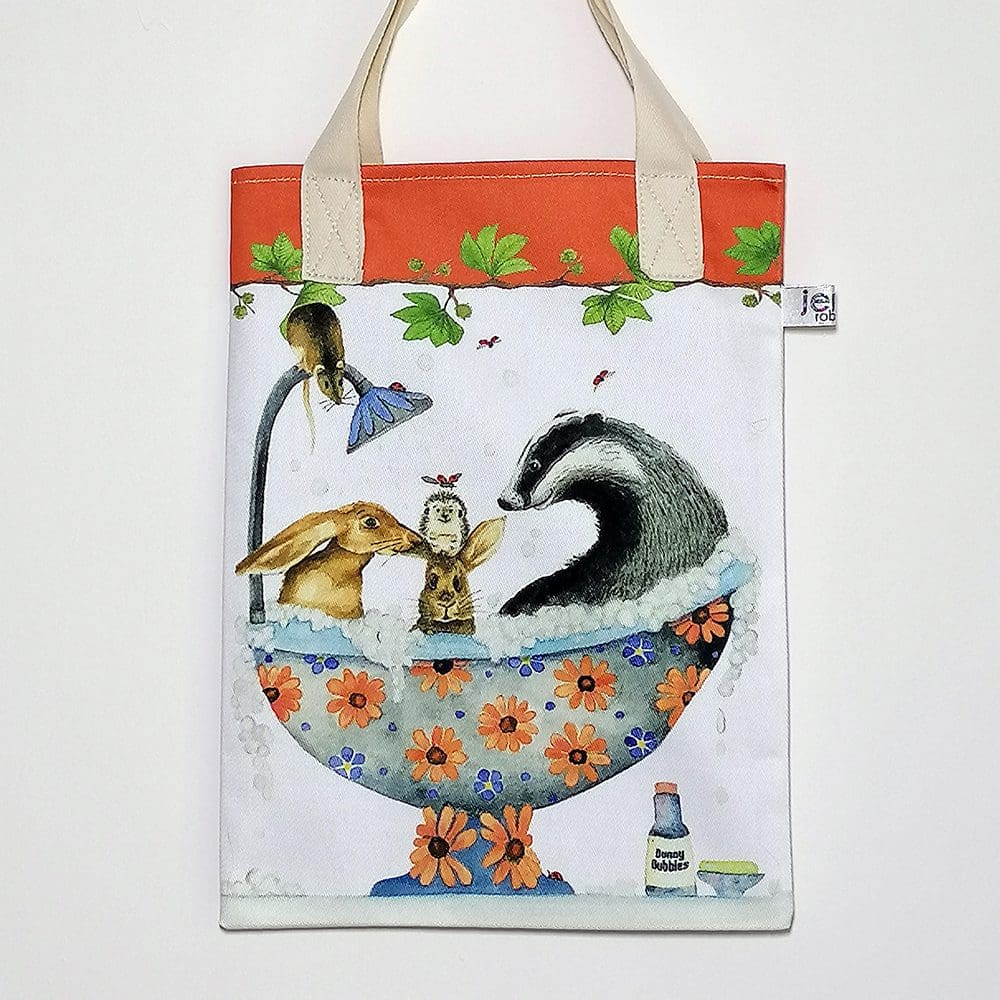 Badger and hare in the bath bookbag. On the front featuring a mix of a Hare, rabbit, badger and hedgehog sharing a bubble bath. On reverse is the 'Love and Friendship logo with a little close up of Mr and Mrs Buttons and Holly Hedgehog. Orange trim on top edge and pale cream cotton handles.