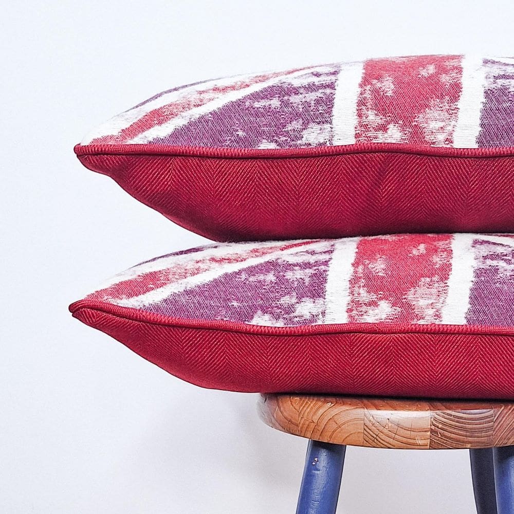 Two Union Jack Cushions perched on a stool.