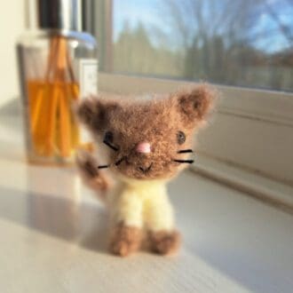 cute crochet fluffy kitten on a window ledge