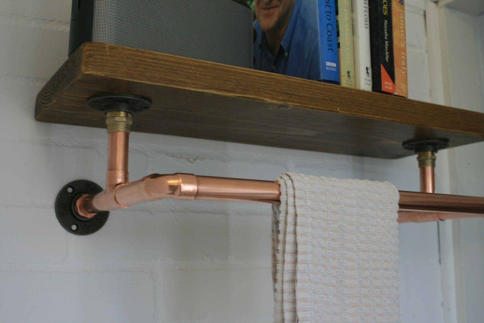copper clothes rail with scaffold board shelf