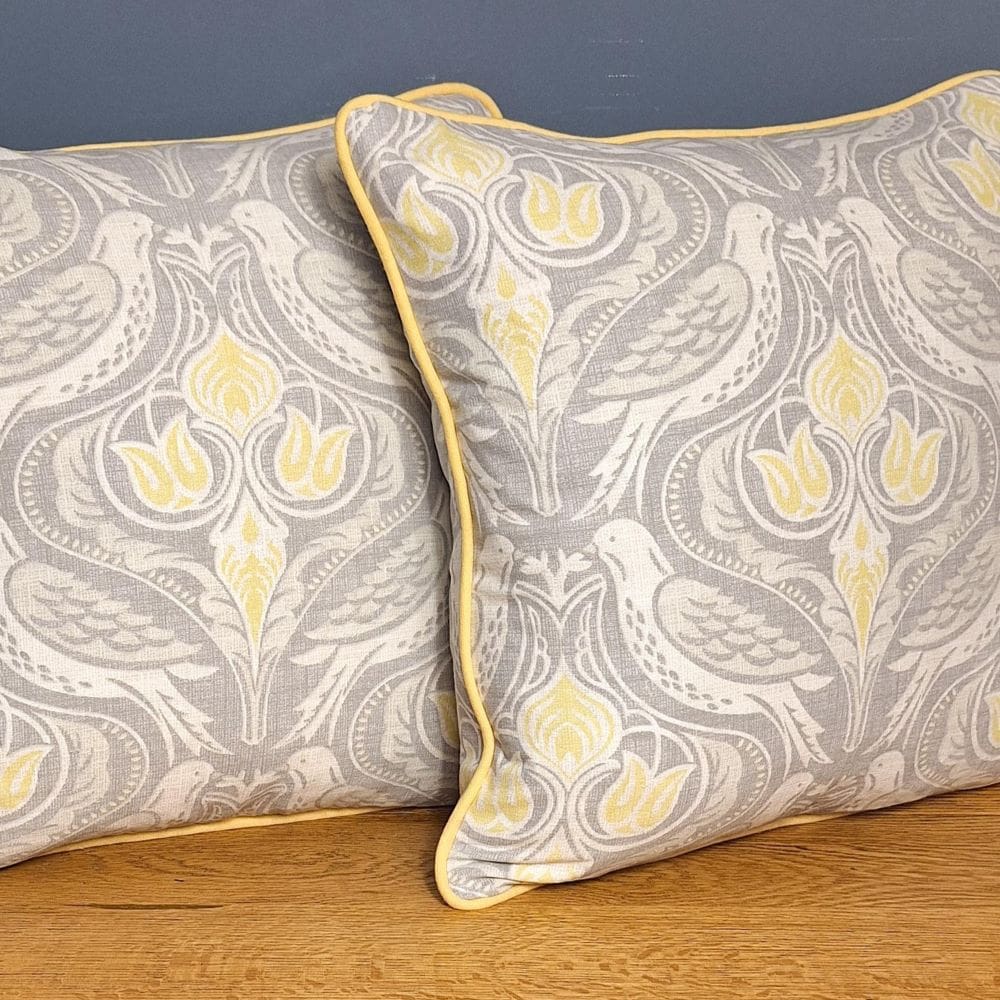 Art Nouveau style cushion cover with yellow piping.