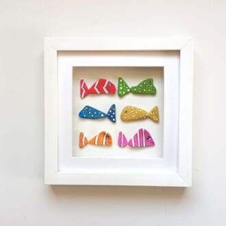 six colourful spotted and striped sea pottery fish in a 24cm frame