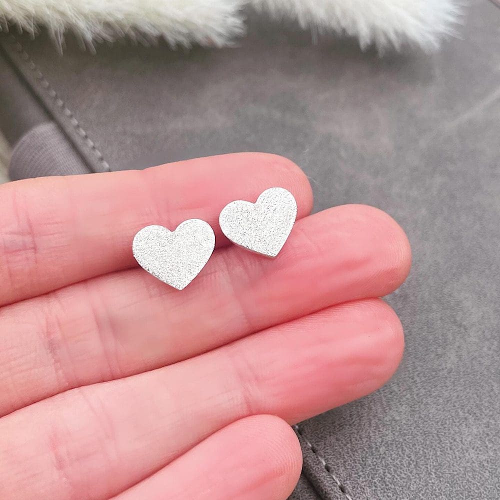 heart studs in hand to show scale