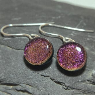A pair of cherry red fused dichroic glass drop earrings viewed from the front