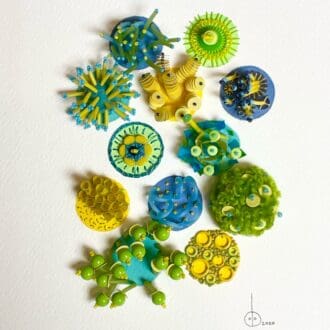 A beautifully embroidered collage of beads and embroidery stitches in lime, turquoise and yellow. The collage layout is in circles each circle is completely different in colour and texture.