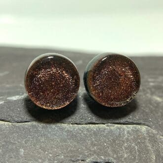 A pair of dark bronze fused dichroic glass stud earrings viewed from the front