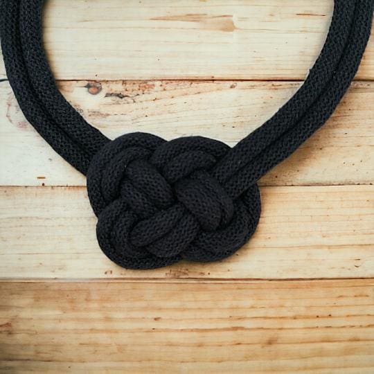 Close up of knot detail on black rope necklace