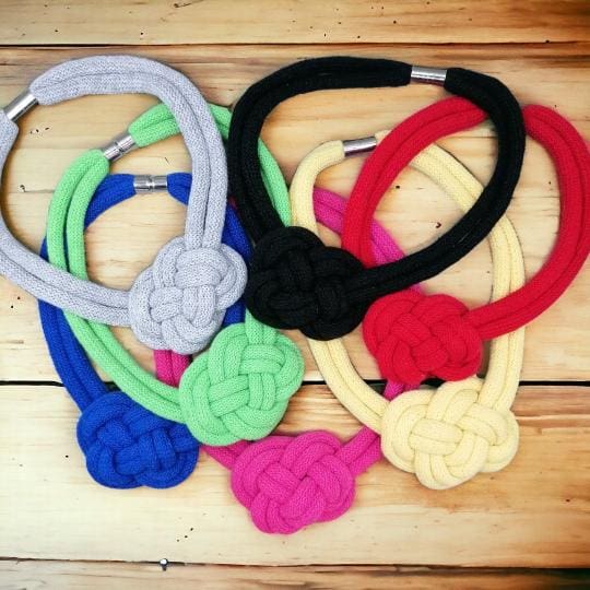 Group shot of colourful selection of rope necklaces with central knot feature.