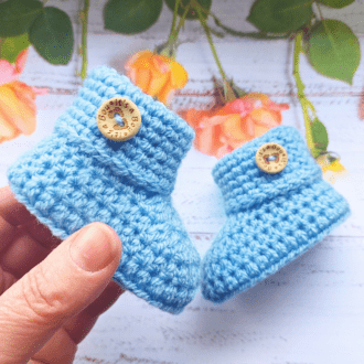 A pair ofcrochet baby booties with a folded cuff and finished with an 'it's a boy' wooden button. Great idea for a gender reveal or a new baby gift. They come in sizes newborn, 0-3 and 3-6 months with a variety of colours to choose from.