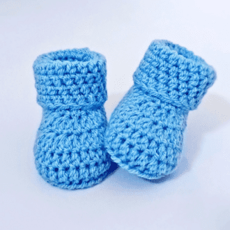 a pair of cloud blue crochet baby booties with a folded cuff, perfect new baby present or baby shower gift