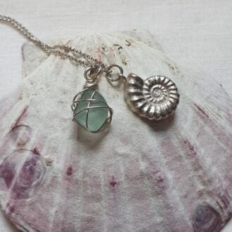 Necklace of a silver ammonite paired with a nugget of ice-aqua sea glass wrapped in fine silver wire - sterling silver chain.