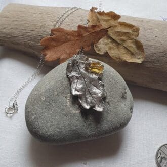 silver oak leaf pendant and small honey amber piece of sea glass on a silver chain necklace