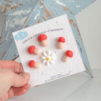 Set of handmade polymer clay mushroom and daisy fridge magnets on seed paper