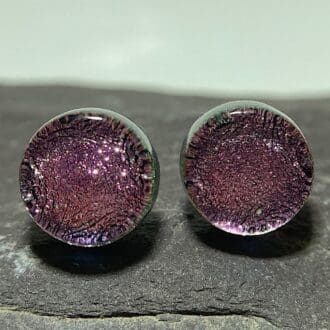 A pair of rose pink fused dichroic glass stud earrings viewed from the front