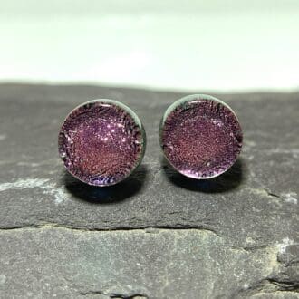 A pair of rose pink fused dichroic glass stud earrings viewed from the front