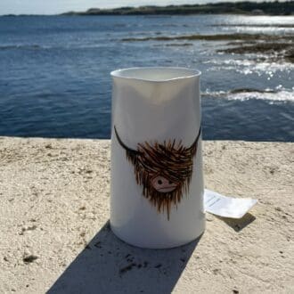 Highland Cow handpainted onto white ceramic jug with sea in background