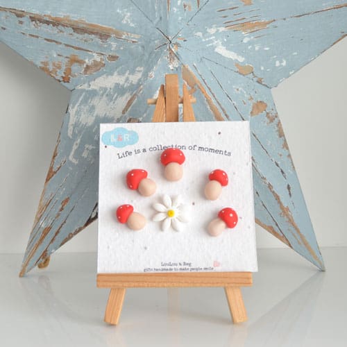 Set of handmade polymer clay mushroom and daisy fridge magnets on seed paper