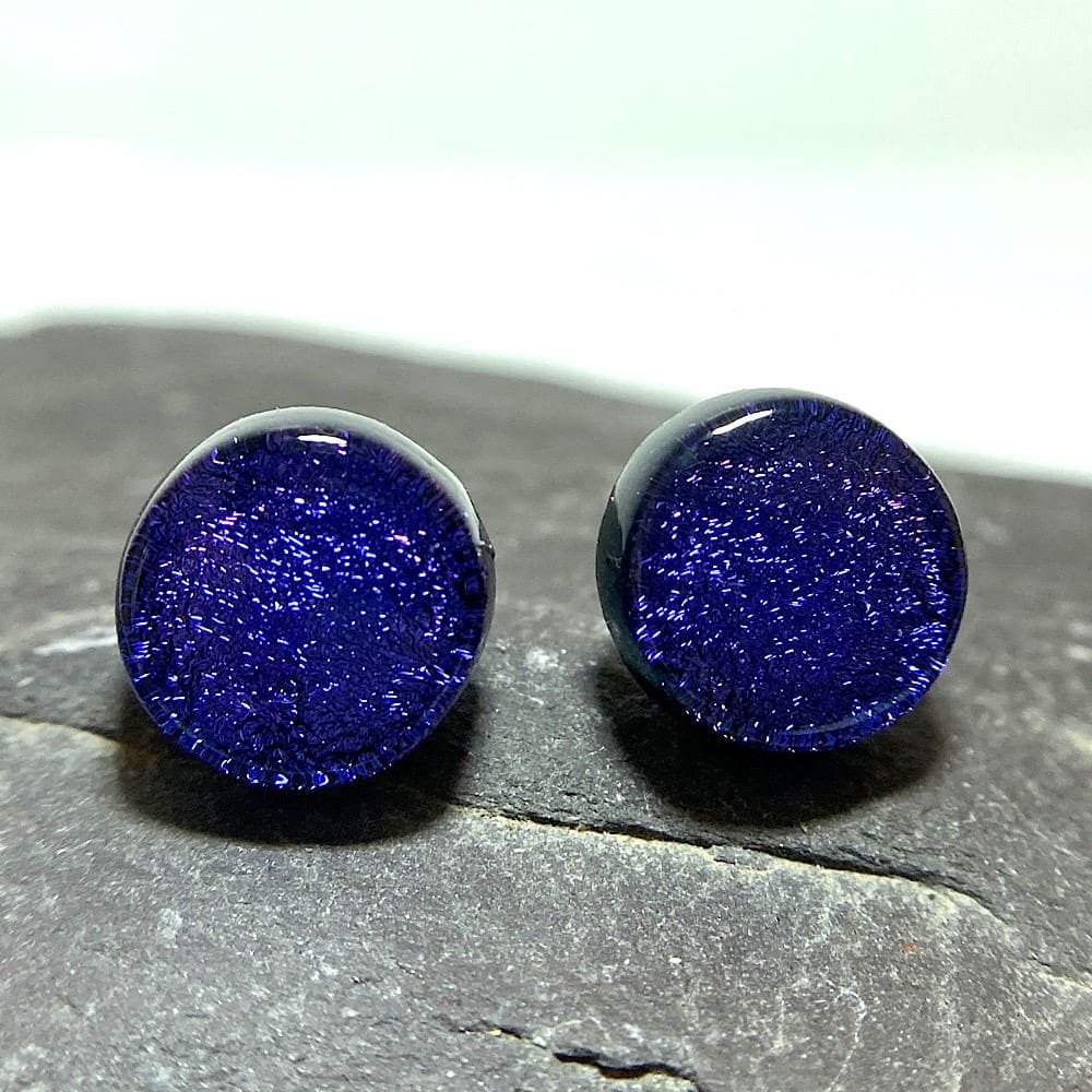 A pair of purple fused dichroic glass stud earrings viewed from the front