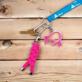 Pink chunky keyring made from knotted recycled cotton cord displayed attached to a bunch of keys on a light wooden background.