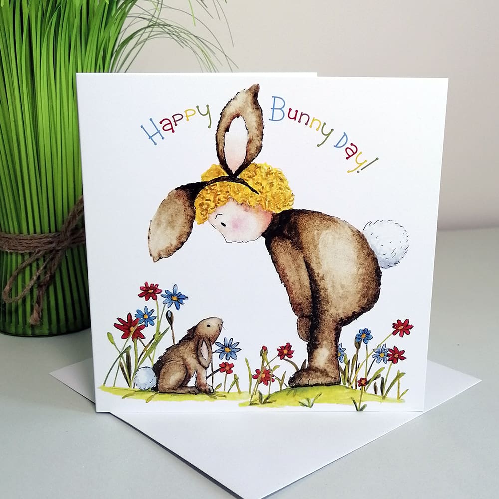 Square, cute greetings card for kids featuring Lulu in her fluffy brown rabbit costume chatting to Bobbie rabbit in the garden.