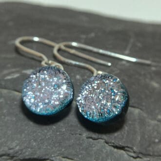 A pair of silver fused dichroic glass drop earrings viewed from the front