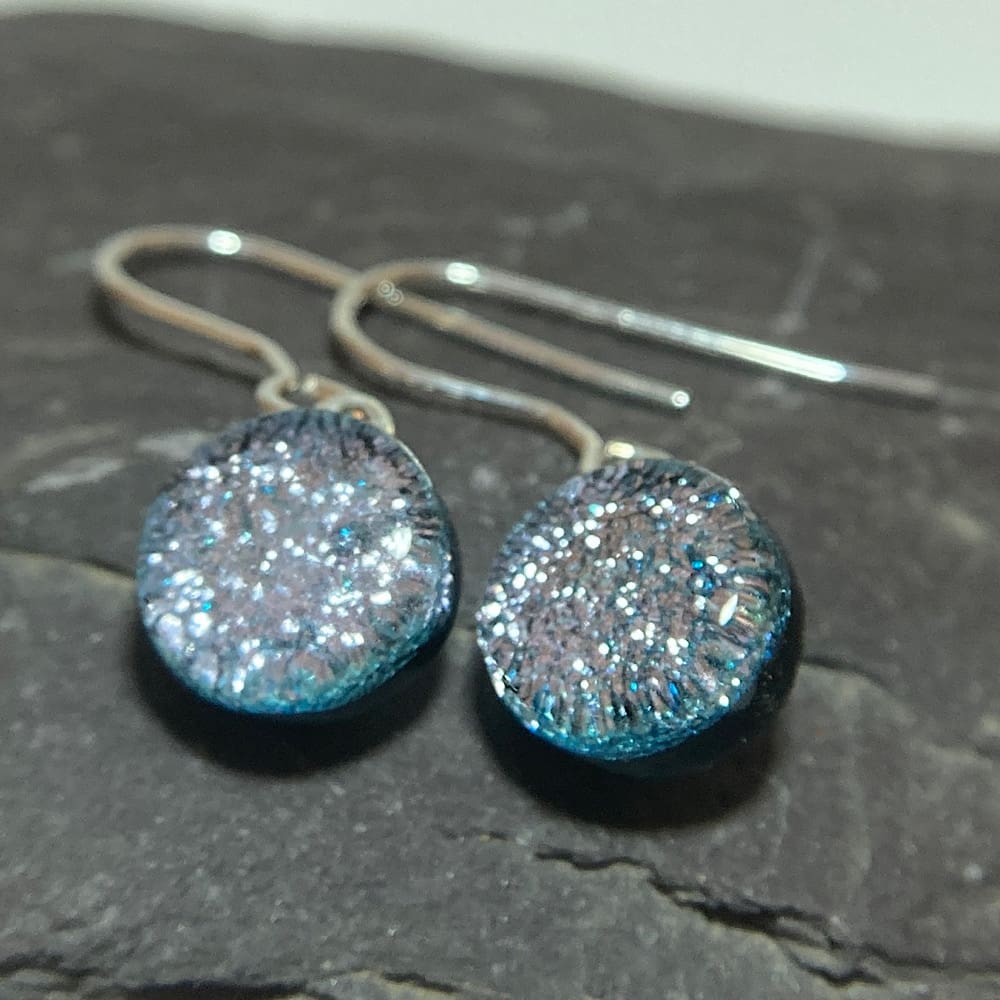 A pair of silver fused dichroic glass drop earrings viewed from the front