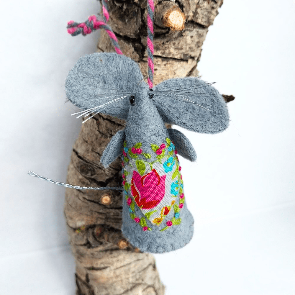 a handmade felt mouse with a bright fabric applique heart and embroidery