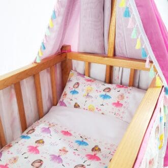 A canopied dolls cots with a pink ballet dancer fabric.