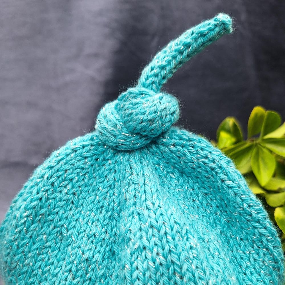 Curly top-knot on a knitted beanie hat by Ambel Crafts.