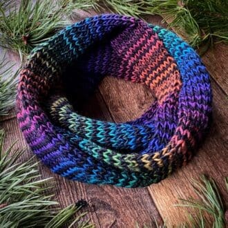 infinity scarf with skinny black stripes alternating with all the colours of the rainbow