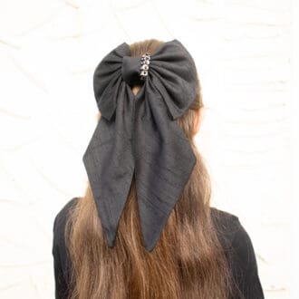 large black hair bow modelled on half-up half-down hairstyle