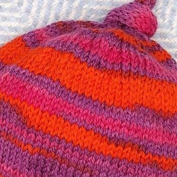 Detail of the excellent knitted stitch definition in a brightly coloured toddlers hat.