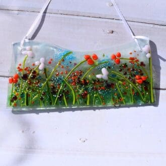 meadow fused glass suncatcher hung from a white satin ribbon
