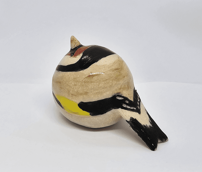Side-rear view of ceramic goldfinch on white background