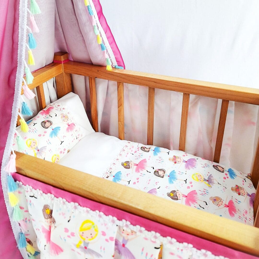Inside a childs toy cot with duvet and bedding themed with cute ballerinas