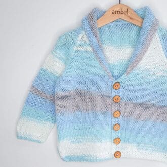 A 2-4year old boy moss stitch shawl-collared cardigan in shades of blue, grey and white with wooden buttons.