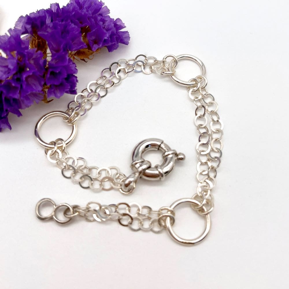 silver bracelet made up of double chain lengths and larger rings with fancy bolt ring fastener