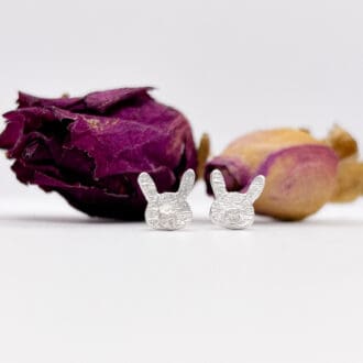 silver easter bunny earrings on a white background with dried flowers