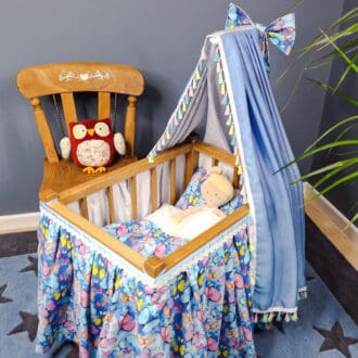 A doll sleeps in the antique style cradle made by Ambel Crafts.