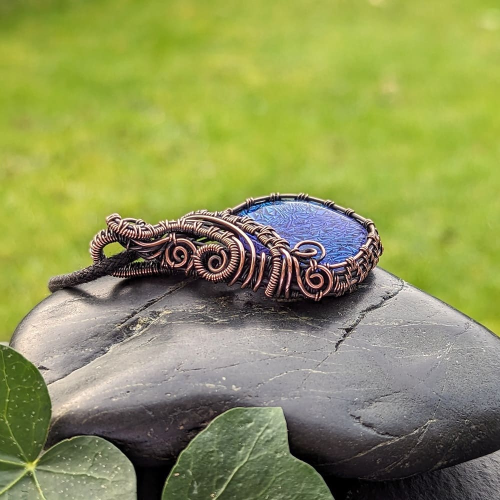 Handcrafted copper wire weave pendant with blue dichroic glass