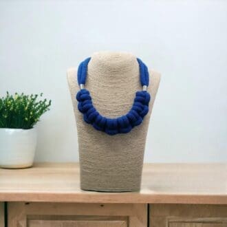 BLue chunky knotted rope statement necklace displayed on a bust model against a light background.