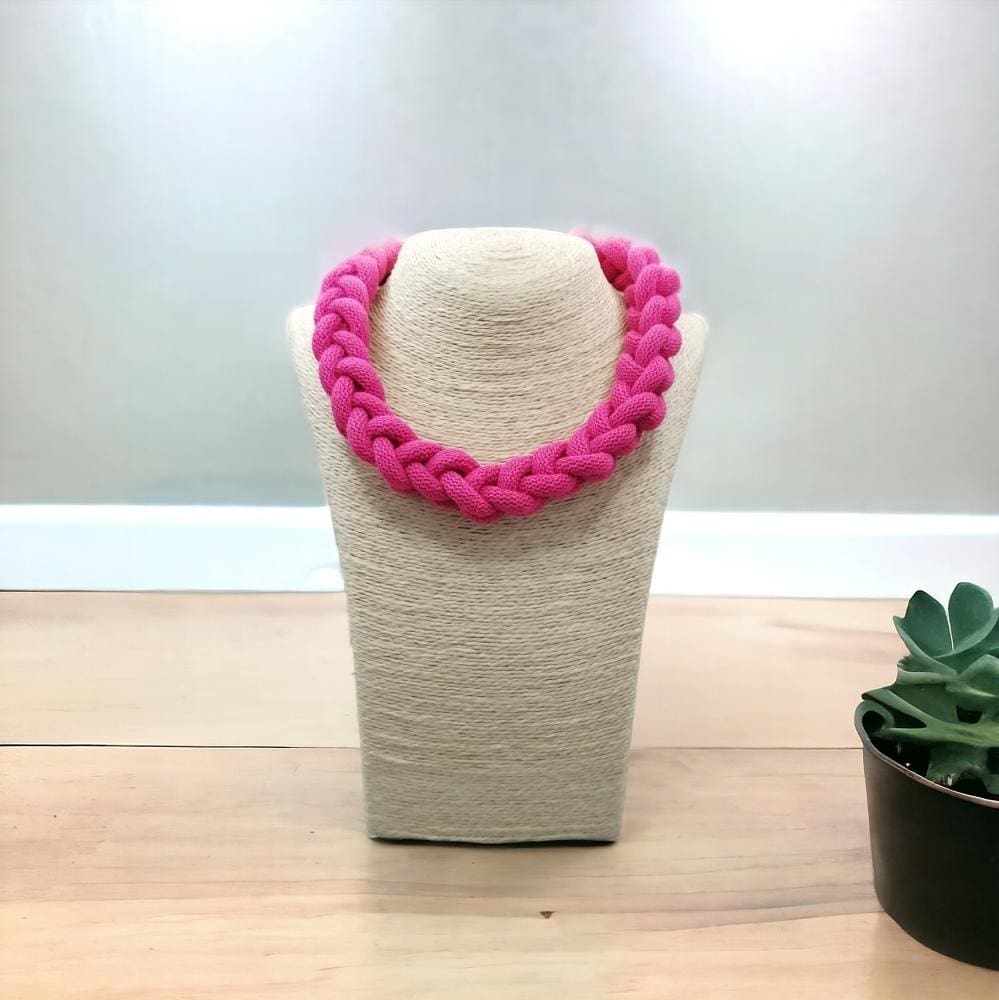 Chunky pink knotted statement necklace displayed on a light coloured bust model against a light background
