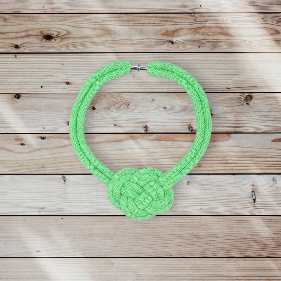 Flatlay overhead view of chunky neon green statement rope knotted necklace