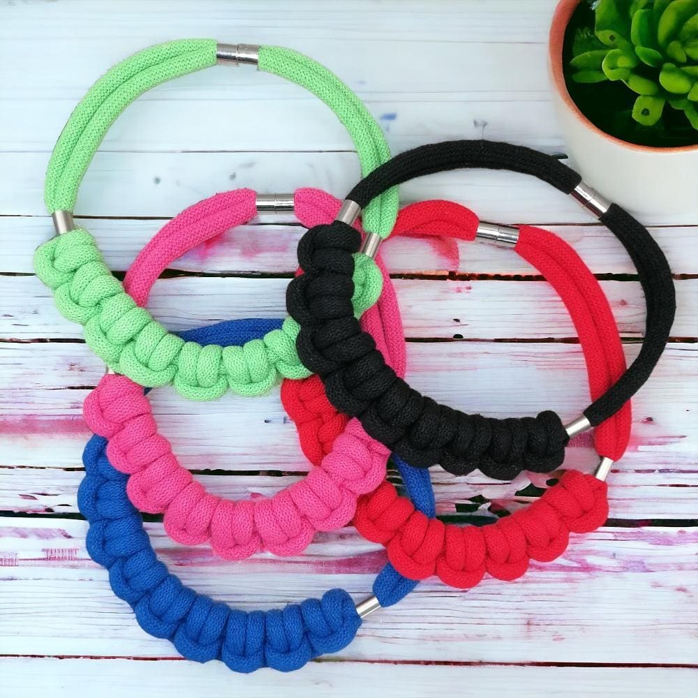 Collection of colourful chunky knotted rope necklaces shown together.