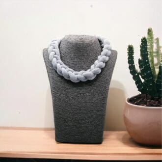 Chunky grey knotted rope statement necklace displayed on a dark bust model against a light background